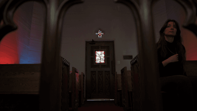 A woman sitting in the front pew of a church